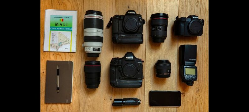 Canon Ambassador Pascal Maitre's kitbag, containing two Canon cameras, lenses, accessories and a notepad and pen. 