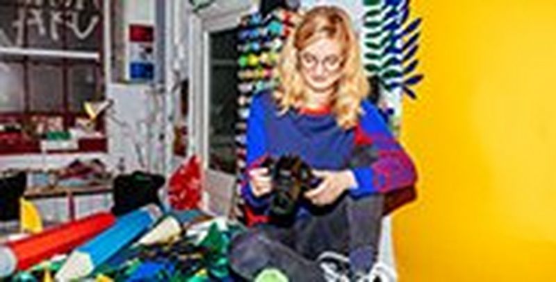 Photographer Hattie Newman holds a Canon EOS 4000D camera.