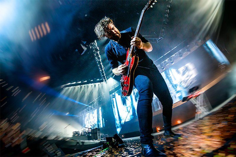 A low-angle, Fisheye lens shot of a guitarist on stage. Photo by Bart Heemskerk.