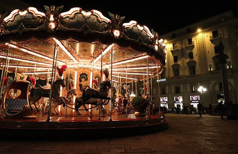 A fairground carousel lit up at night.