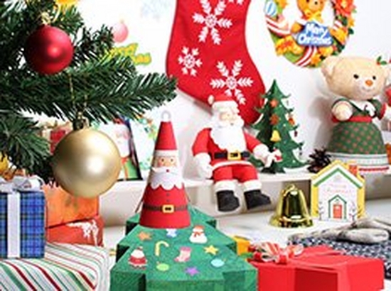 A table is filled with Christmas-themed paper crafted decorations and gifts.