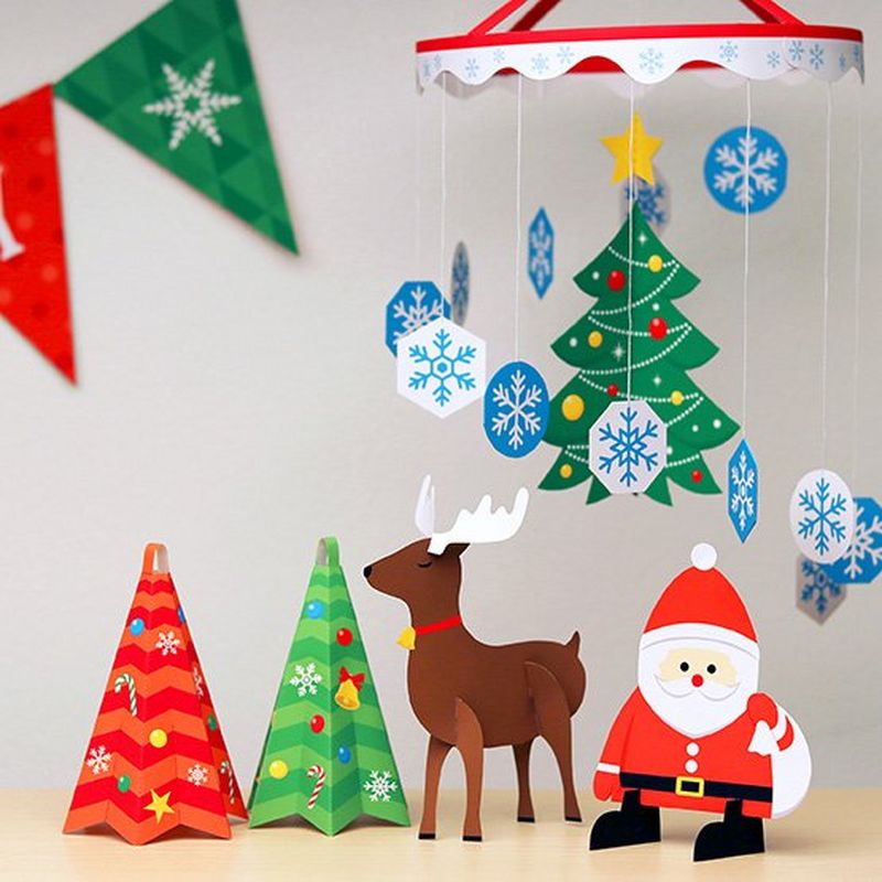 A variety of homemade Christmas decorations including Santa, a reindeer, and a mobile with a twirling Christmas tree and snowflakes.