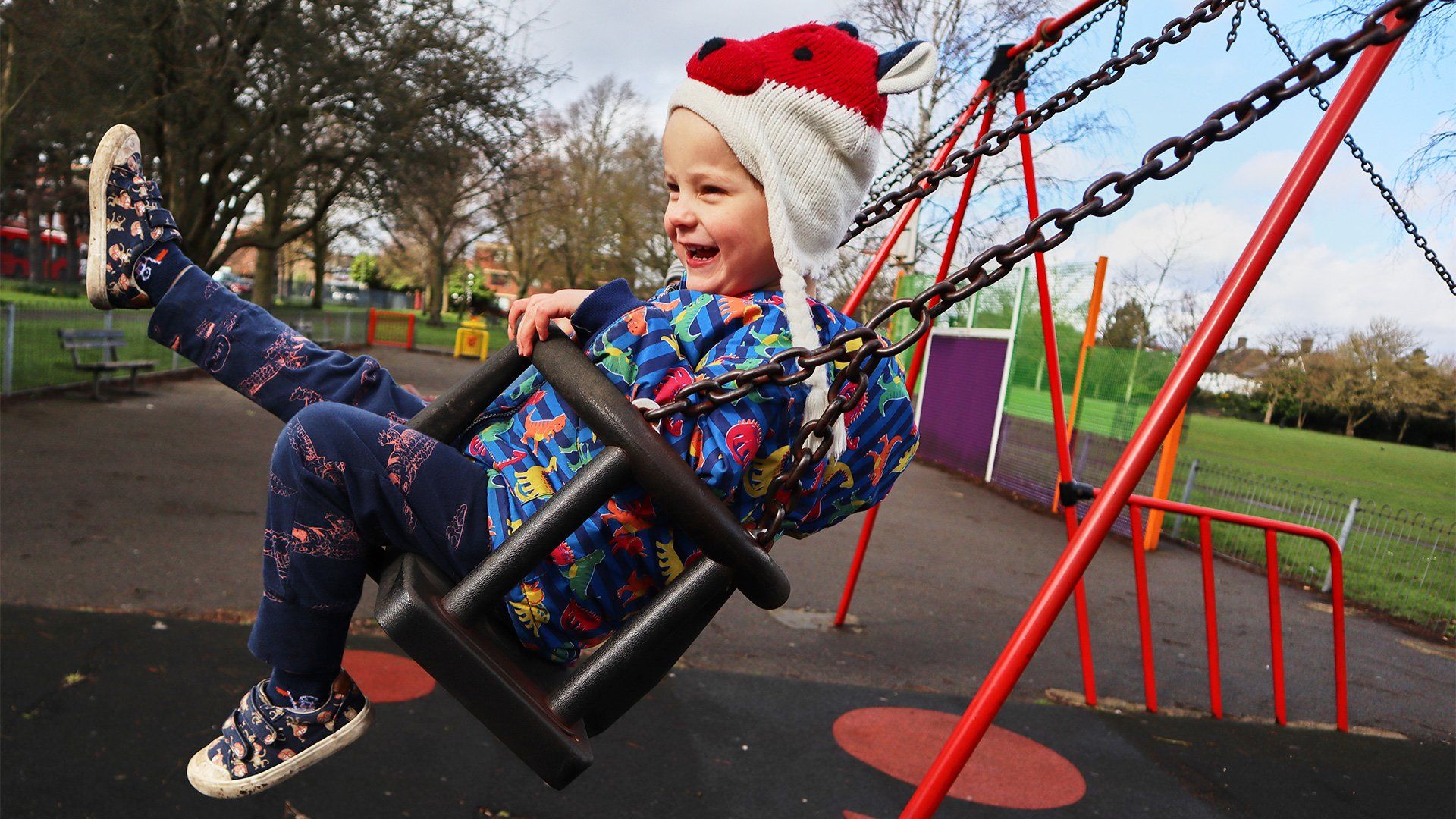 A young boy swings on a swing, laughing. Taken on a Canon EOS M50 by Katja Gaskell.