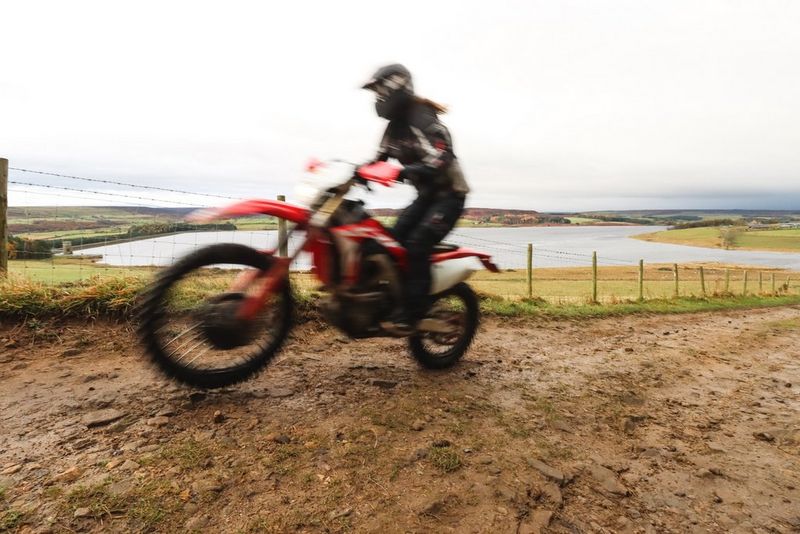 A blurred shot of a rider on a dirt-bike, the background in focus.