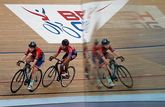 As two cyclists race along a velodrome track, they are reflected in a mirror-like surface. Photo by Eddie Keogh.