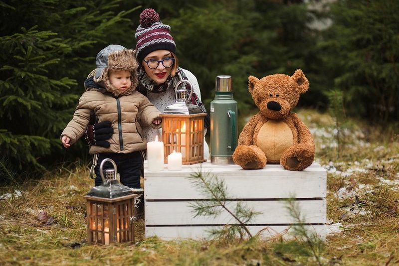 A mother and child look at a Christmas display outside.