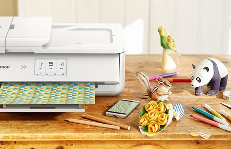 A Canon printer prints out patterned paper. A phone is next to the printer showing the same pattern.