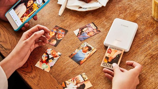 Woman printing photo cards using a Zoemini printer.