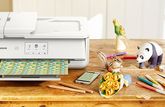 A Canon printer on a table with a papercraft panda and bouquet of flowers. 