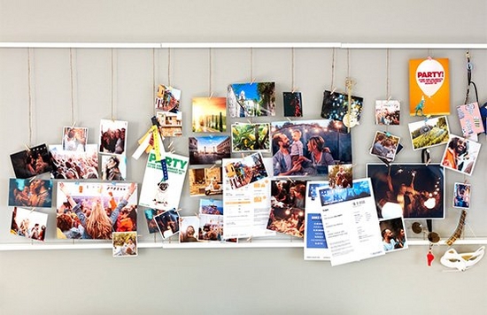 Printed photos, invitations and flyers on a pin board.