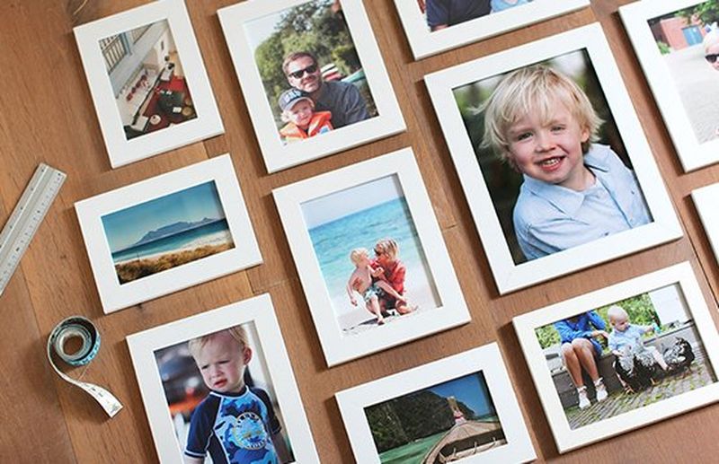 Printed photos in white frames laid out artistically.