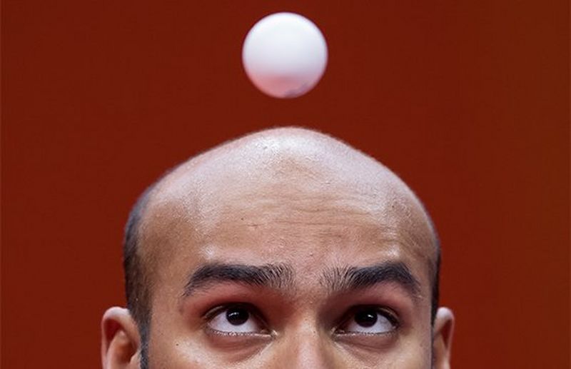 A close-up of table tennis player Rhikesh Taucoory with the ball appearing to hover just in front of his face. Photo by Mark Kolbe.