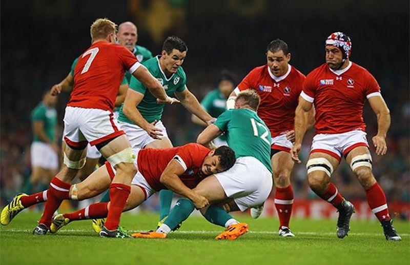 A Canadian player tackles an Irish player in a rugby match. Photo by Richard Heathcote.