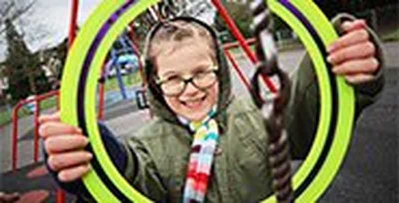 A girl holds a frisbee in front of her face like a picture frame.