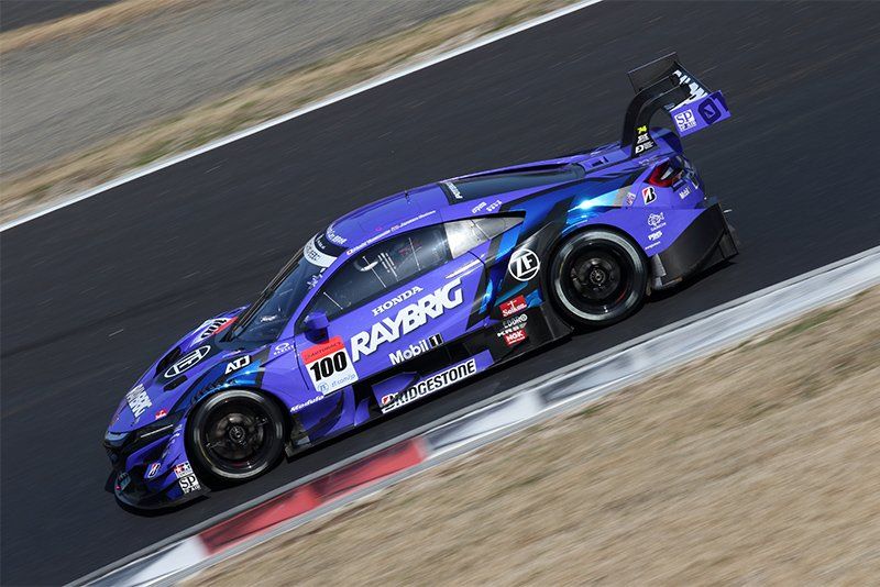 A sports car on a race track; the car is in sharp focus, with everything else blurred.