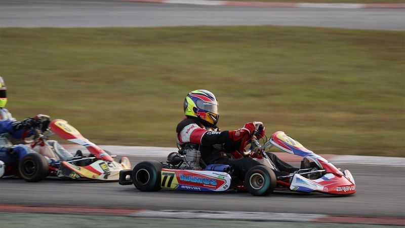 Two go-karts racing on a track; the front one is in sharp focus, with everything else blurred.