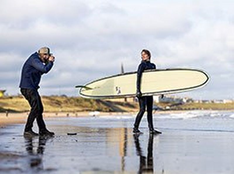 A trail runner captured jumping in the air on a rocky beach, creating a bold silhouette.