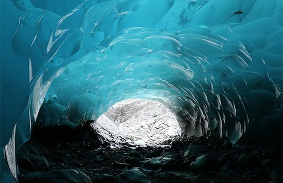 The inside of a bright blue ice cave.