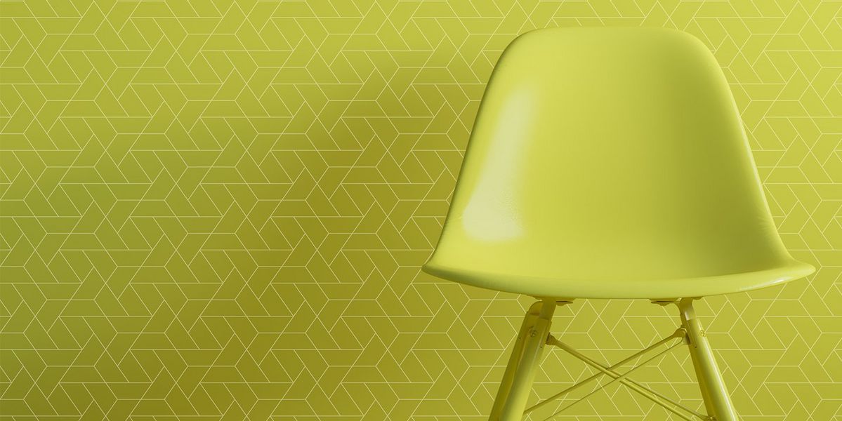 A green chair in front of digitally printed green wallpaper