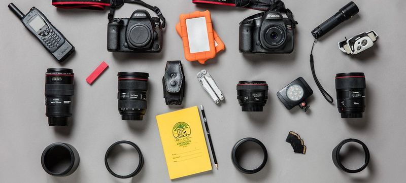 The contents of Paolo Verzone's photography kitbag are laid out, showing Canon cameras and lenses.
