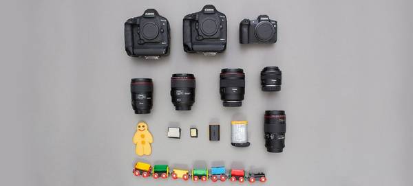 Two Canon EOS-1D X Mark II camera bodies, a Canon EOS R body, and various lenses, batteries and memory cards, plus a child’s toy train and gingerbread man.