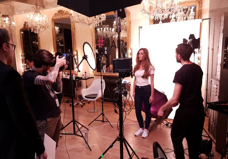 Videographer Quentin Caffier holds a Canon camera filming a woman in a hairdressing salon.