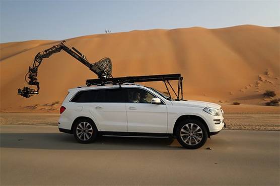 A car in the desert has a Canon EOS C700 FF attached to a crane arm out the back.