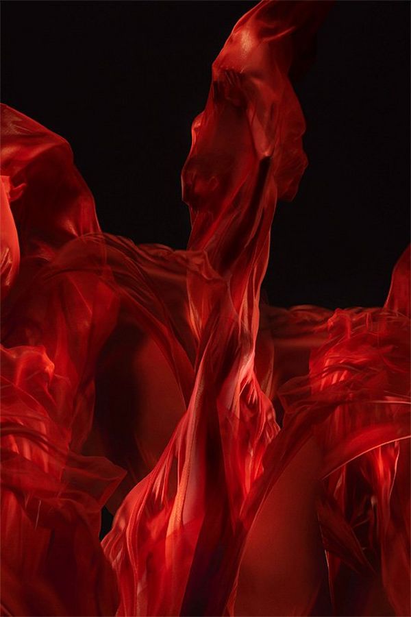 A ballet dancer shrouded in billowing red silks with the appearance of dancing flames.