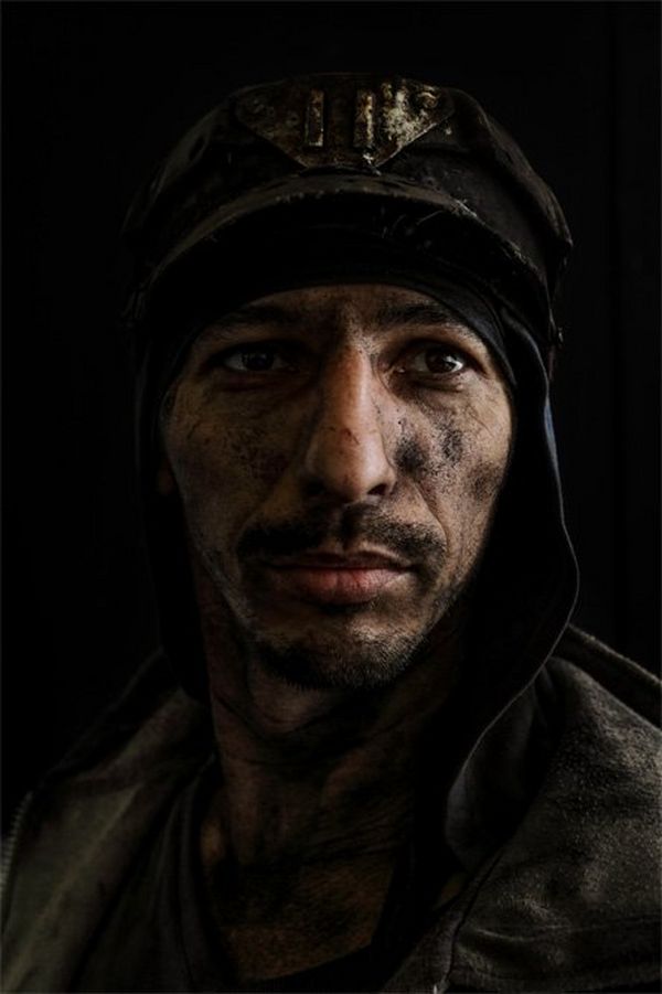 A portrait of a miner with only half his face illuminated 
