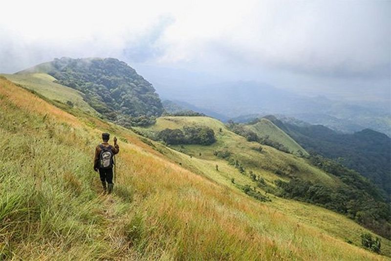 A walker on a grassy mountain slope, photographed by Daniël Nelson on a Canon EOS 6D.