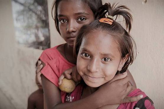 Two girls embrace each other in Kolkata, during the making of McCullin in Kolkata for Canon Europe.