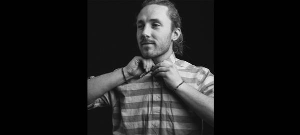 Filmmaker Spencer MacDonald buttons up a striped shirt.