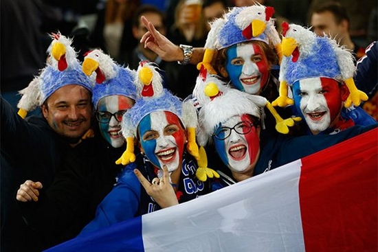 French fans with painted faces holding a flag at a France v Romania match in Rugby World Cup 2015.