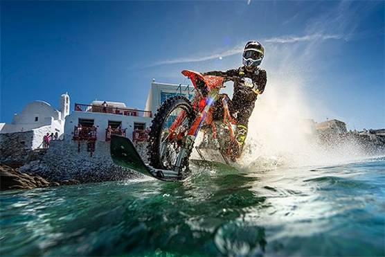A driver on a customised dirt bike, riding it on the water.