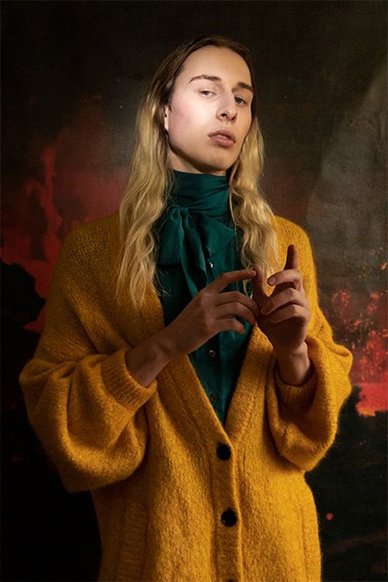 An androgynous long-haired model stands in low light. Photo by Wanda Martin on a Canon EOS-1D X Mark II.