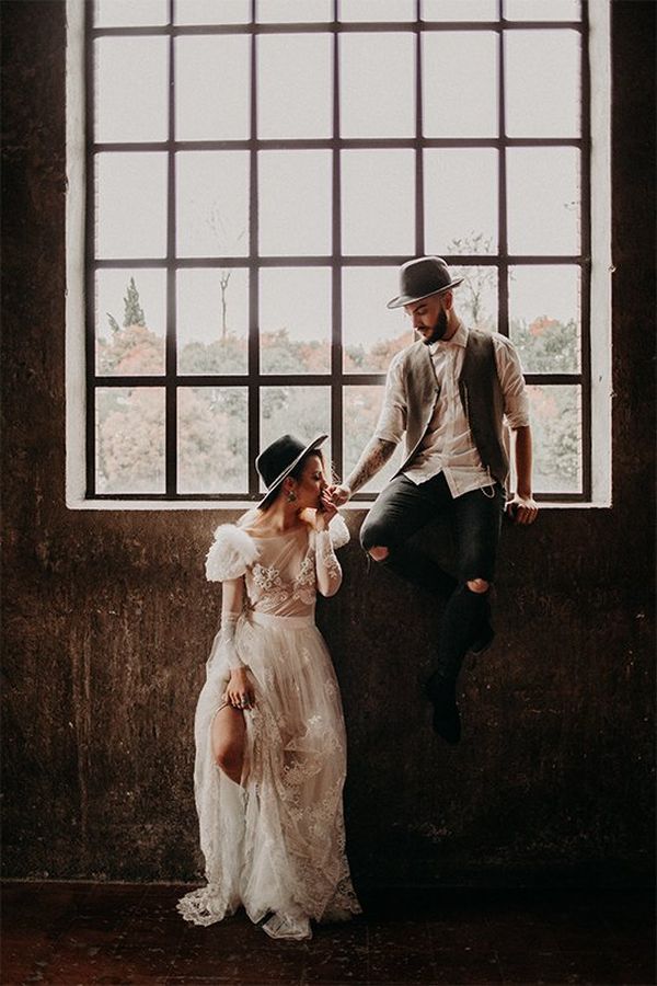 Bride poses against wall while the groom sits on the window ledge. Photo by Factoria182. 