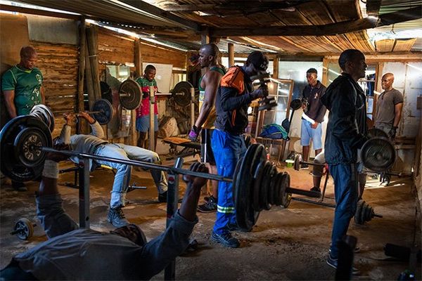Men working out in a makeshift gym.