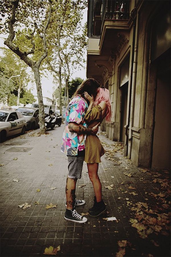 The couple kiss under the trees on a deserted street in Barcelona.