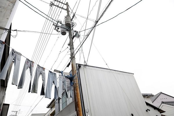 In a film still from Made in Japan, jeans hang across the entrance to Jeans Street, in the Okayama prefecture of Japan.