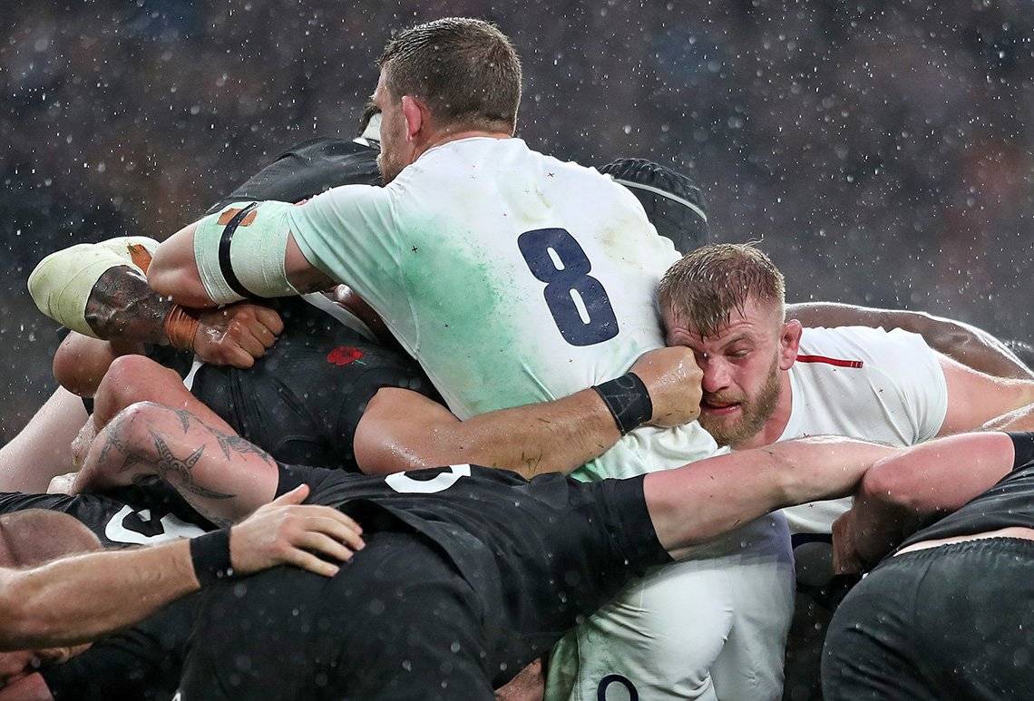 England and New Zealand rugby players in a ruck, photographed by Marc Aspland.