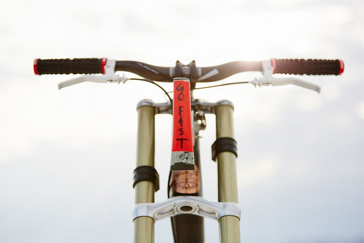A bicycle's handle bars and front are seen, the words 'Go fast' stuck on.