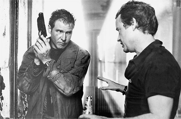 Harrison Ford dressed as Rick Deckard on the set of Blade Runner, talking to director Ridley Scott