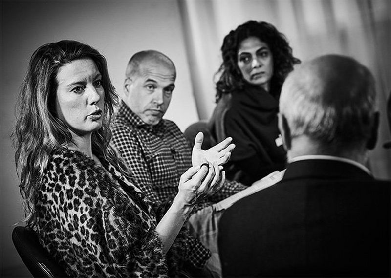 Female photographer Ilvy Njiokiktjien speaks in the discussion, while the other debaters listen.