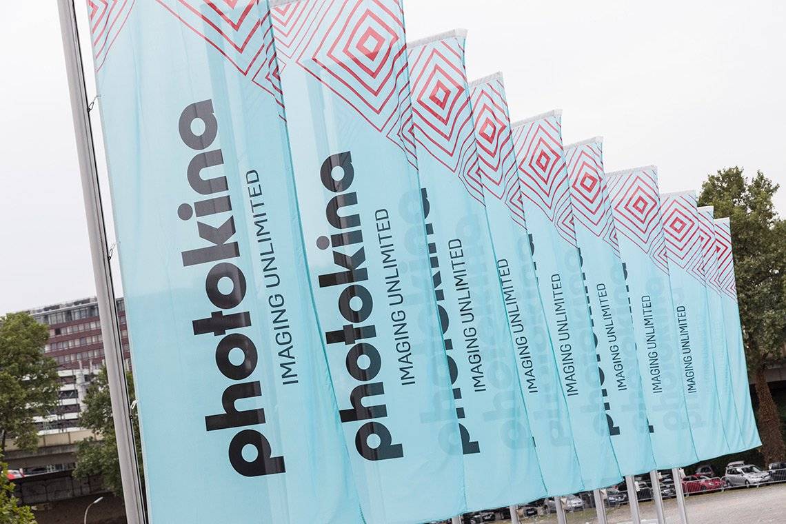 A row of light blue flags at the entrance to the Photokina trade show.