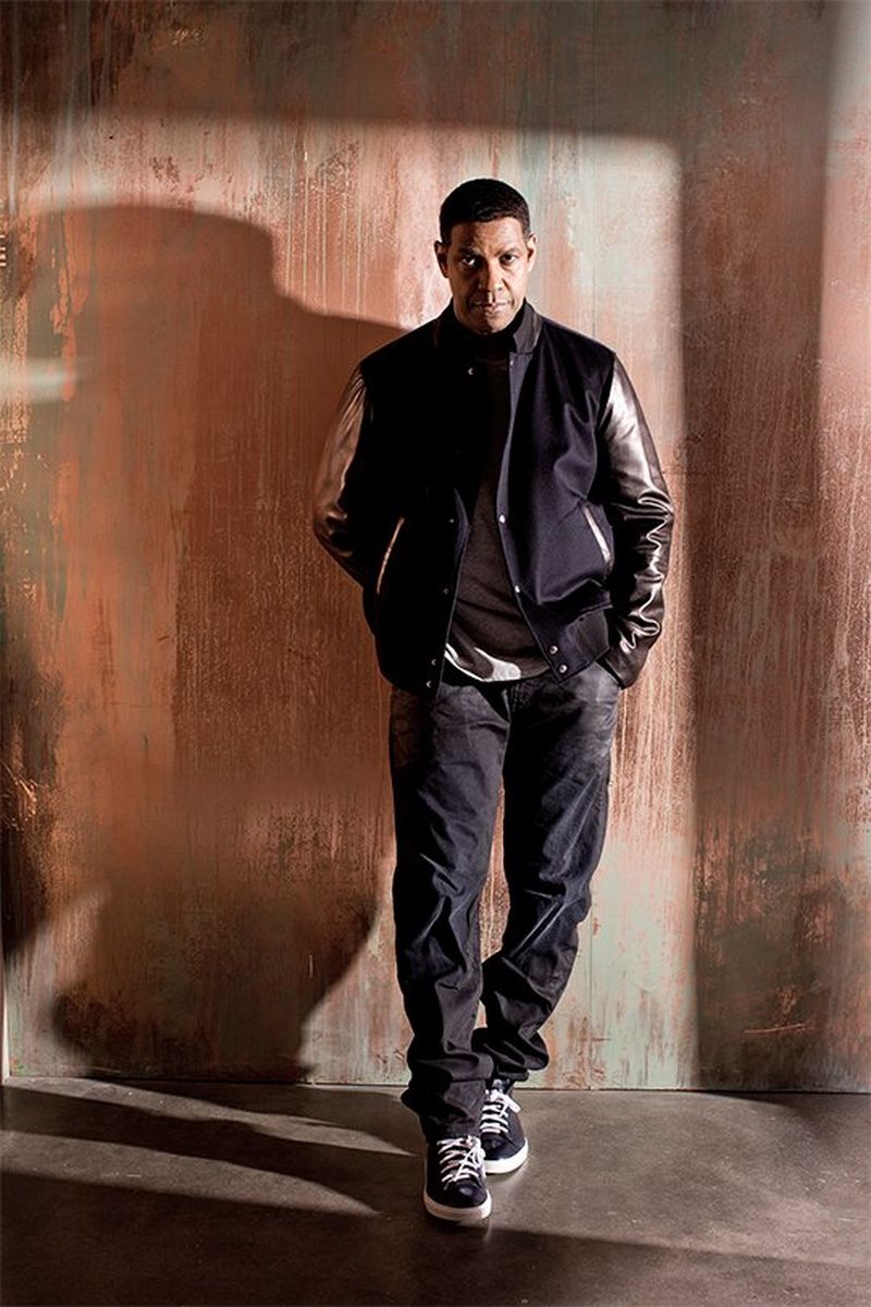 Denzel Washington stands against a distressed orange wall. Portrait by Lorenzo Agius on a Canon EOS 5D Mark III.