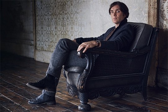 Irish actor Cillian Murphy, wearing a dark jacket and trousers, sits in a black armchair looking at the camera. Portrait by Lorenzo Agius.