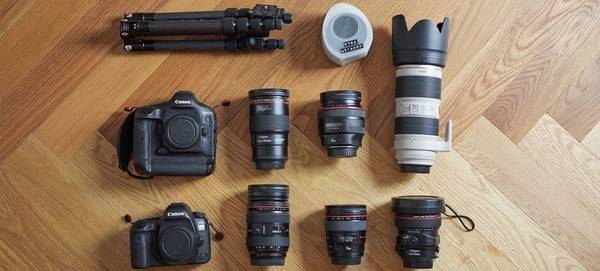 Quentin Caffier's photo kit on a wooden floor, including an ֽ_격- plus several lenses.