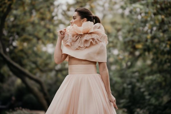 A model in a frilly wedding dress, photographed against a blurred background using the Canon RF 85mm F1.2L USM DS lens with Defocus Smoothing.