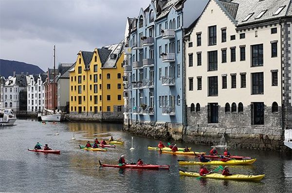Kayakers on a river beside colourful houses, taken with a Canon RF 24-240mm F4-6.3 IS USM lens.