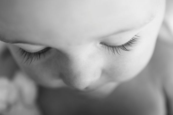 A close-up of a baby's face, looking down. Taken by Helen Bartlett.